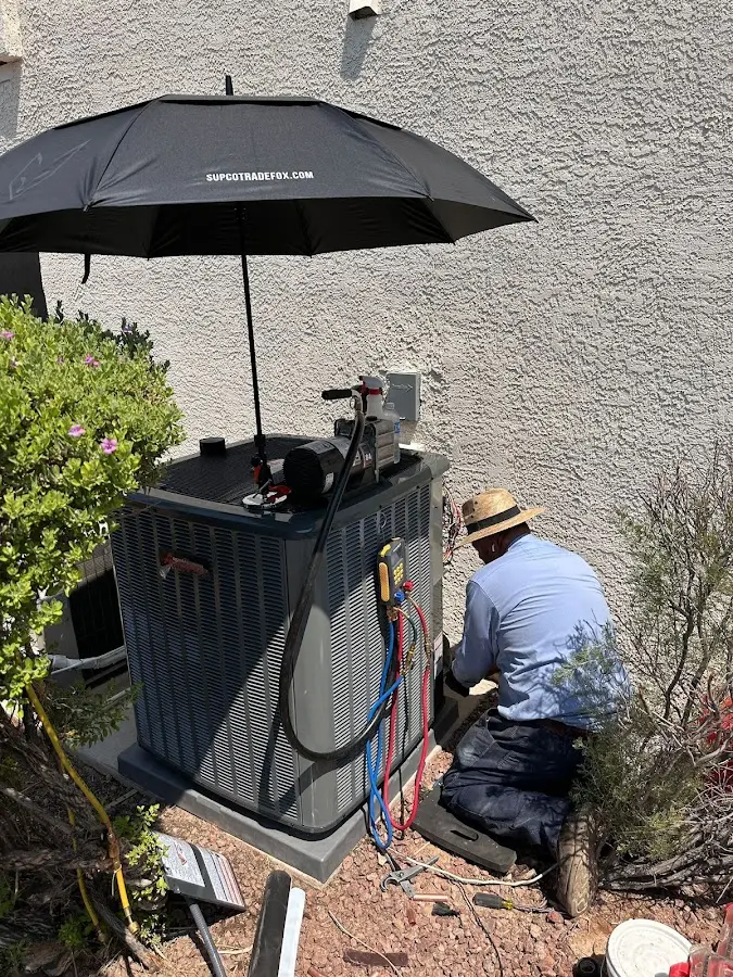 HVAC technician performing outdoor AC maintenance in Fort Edward