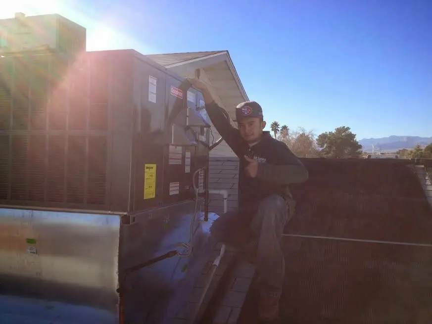 HVAC technician performing Heat Pump Repair on a rooftop unit in Fort Edward